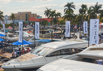 Group viewing yachts of various brands like Azimut and Galeon at boat show