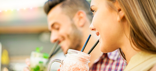 Mand and woman enjoying drinks in glass jars