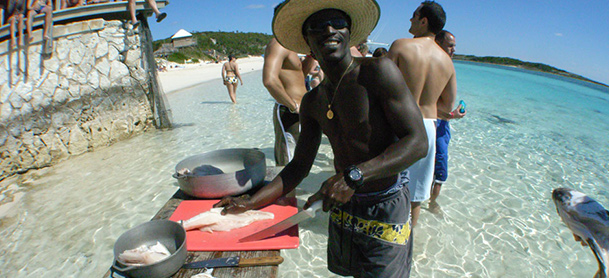 Man cleaning and preparing fish at shore