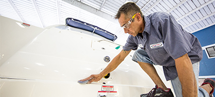 man in uniform polishing yacht deck